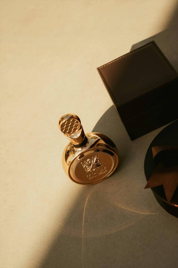 Gold perfume bottle beside a custom presentation box