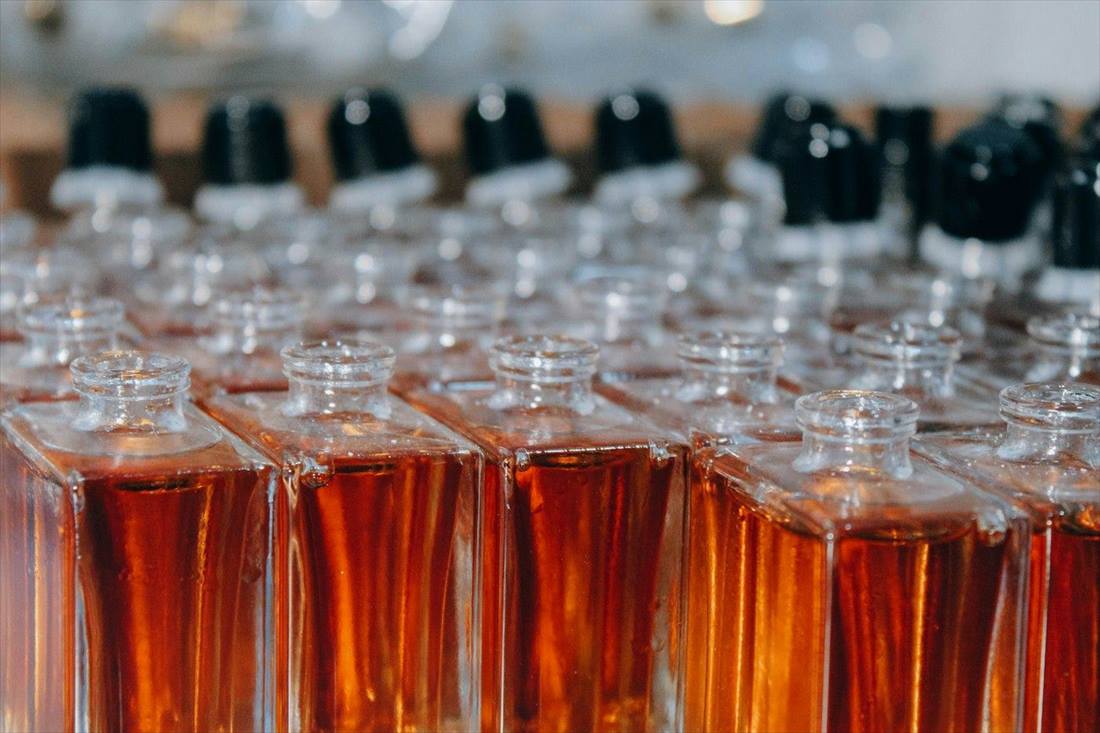 Rows of filled perfume bottles ready for labelling