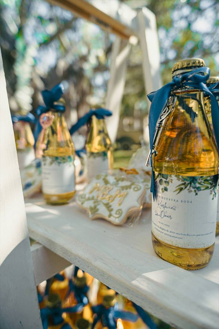 Small bottles with golden caps and ribbons as wedding favours